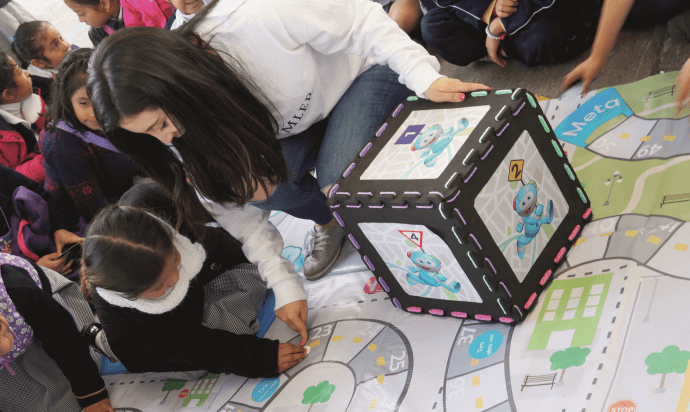 A women plays with a child on a carpet which shows streets.